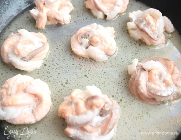 Добавить белое сухое вино. Накрыть сковороду крышкой, тушить рыбу 7 минут на минимальном огне.