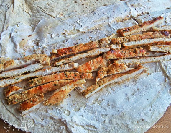 Отступив от края, разложить полоски курицы.