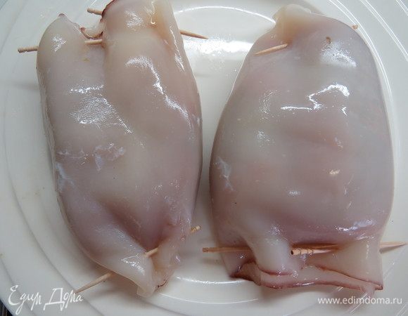 Тушки кальмаров сколоть по краям зубочистками, чтобы соки от рыбы остались внутри. Пропитанный рыбными соками кальмар очень вкусен!