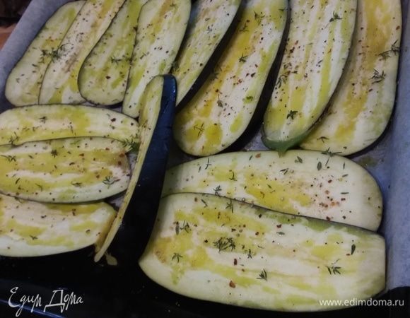 Баклажаны нарезать вдоль на слайсы, выложить на противень, сбрызнуть оливковым маслом, посолить и поперчить, присыпать листиками тимьяна. Запекать в заранее разогретой духовке под грилем с каждой стороны по 10 минут. Противень вынуть из духовки и отставить в сторону.