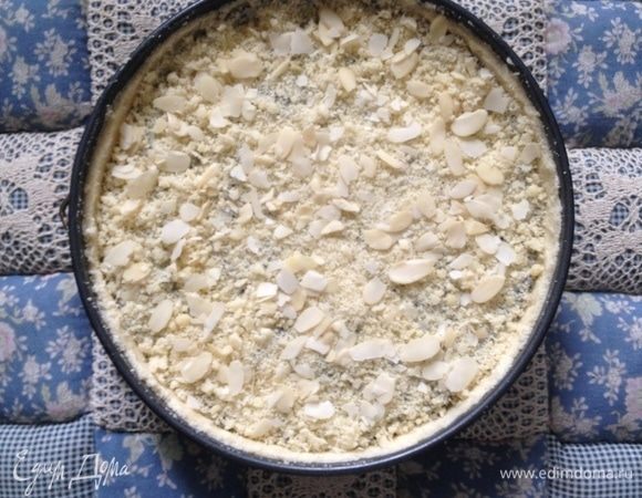 Сверху присыпать отложенной крошкой и миндальными лепестками. Выпекать при температуре 180°C 50–60 мин.