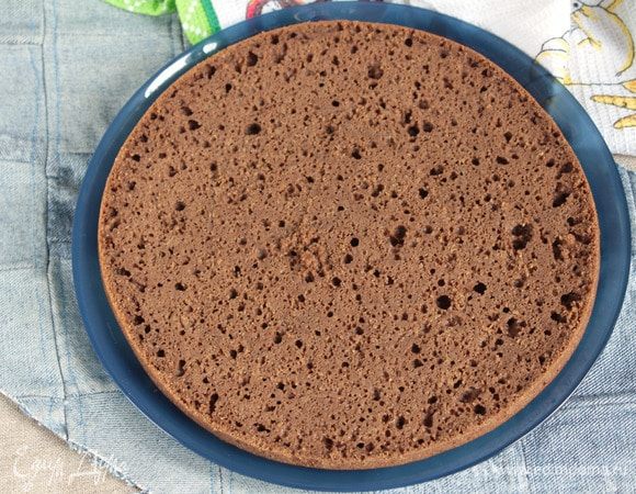 Теперь можно приступать к сборке тортика. Корж «Гречанка» разрезать на два коржа. Корж, который с горбушкой, выложить на сервировочное блюдо. Установить кондитерское кольцо. Я использую картонное кольцо, обернутое бумагой для выпечки.