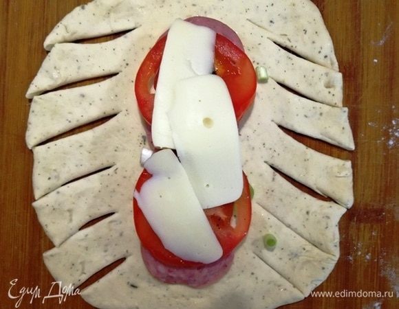 Формируем пиццу. Можно традиционно сформировать пиццу в полукруг, но мы сделаем красиво. Надрезаем заготовку по краям.