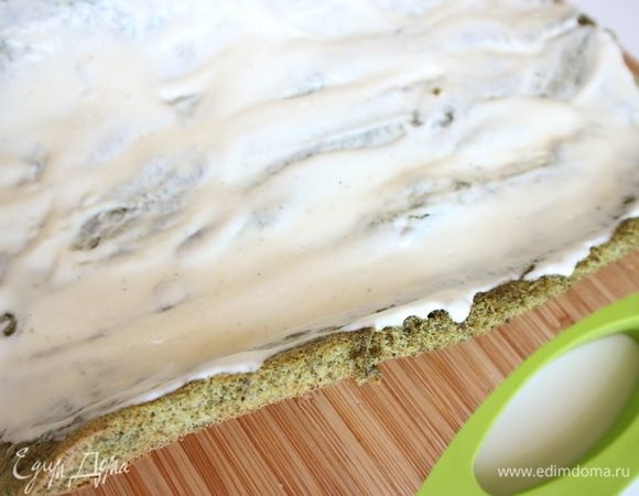 Сливки, сметану и сахарный песок взбить и промазать равномерно бисквит по всей поверхности. Свернуть рулет. Подрезать короткие края у рулета острым ножом.