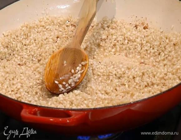 В сотейник с маслом всыпать рис и сделать тостатуру: прогревать, постоянно помешивая, 1–2 минуты, пока рис не станет прозрачным.
