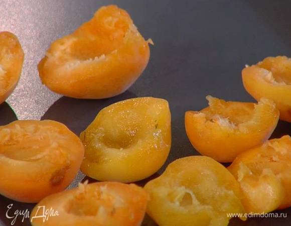 Абрикосы разрезать на половинки и, удалив косточки, выложить на противень плоской стороной вверх.