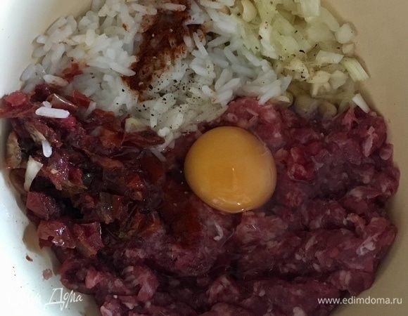 В миске смешать говяжий фарш, мелко нарезанный лук и чеснок, добавить уже сваренный рис ТМ «Националь». Хитрый секретный ингредиент, преображающий перчики — это вяленые помидорки, я взяла 7 половинок и мелко порубила. Далее вбить одно яйцо. Посолить по вкусу. Из специй добавить острый перец и красную паприку. Перемешать. Фарш готов.