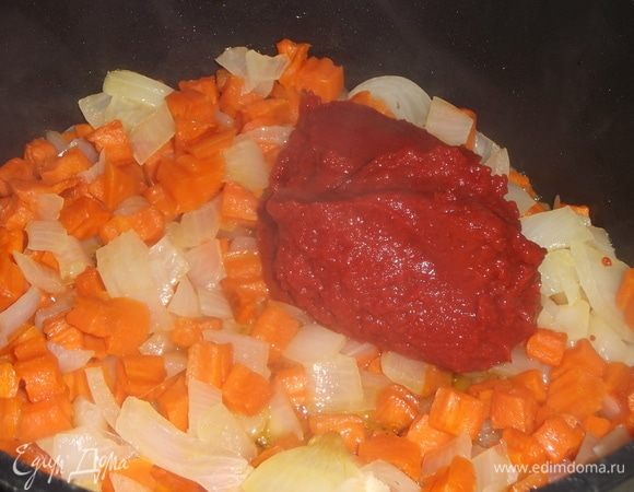 Положить в овощи томатную пасту и сахарный песок. Тушить 15 минут под крышкой.