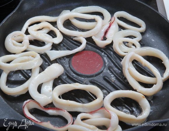 Сковороду-гриль (можно взять и обычную) смазать тонким слоем растительного масла, обжарить кольца кальмаров на сильном огне 2–3 минуты. Затем убираем кальмаров со сковороды, откладываем в сторону.