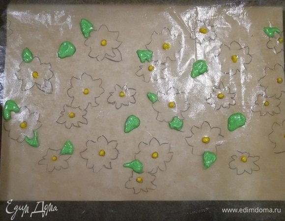 С обратной стороны пергамента для выпечки делаем рисунок. Я сделала самый простой — цветы. Под пергамент подложила альбомный лист, чтобы рисунок был хорошо виден. Смазываем пергамент сливочным маслом. Делаем серединки цветов и листики. Убираем противень в холодильник на 5 минут.