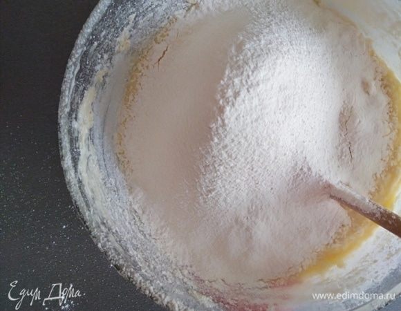 Муку и разрыхлитель просеять и постепенно добавить к жидкой смеси. Ложкой перемешать все до однородности.