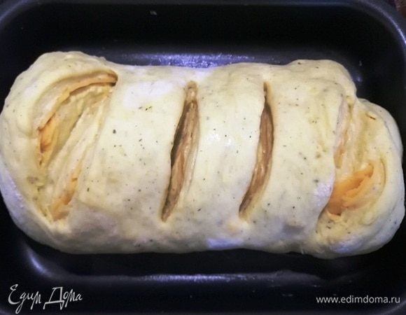 Перекладываем на противень, делаем надрезы. Накрываем чистым полотенцем и оставляем на 10 минут. На фото уже отдохнувшее тесто.