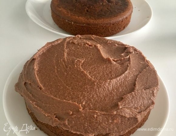 Собираем торт. Положить первый полностью остывший корж на блюдо, пропитать его кофейным соусом. Распределить поверх коржа 1/3 крема.