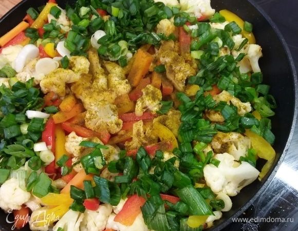 Добавить соевый соус, порошок карри, соль и перец по вкусу. Выложить зеленый лук. Перемешать.