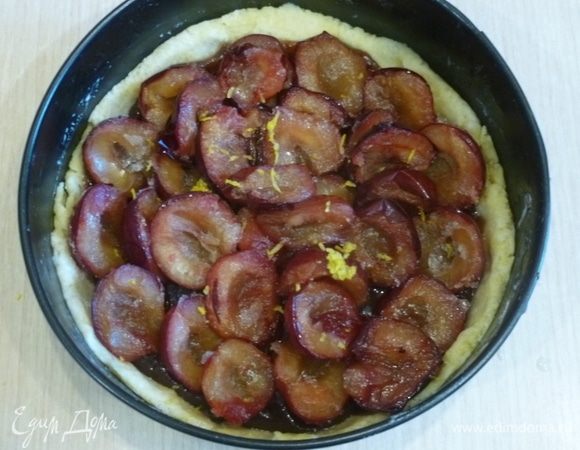 Разложить половинки слив и натереть цедру лимона.