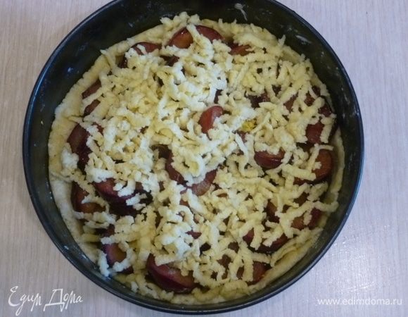 Сверху на крупной терке натереть меньшую часть теста.