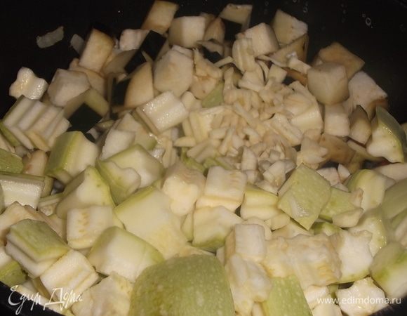 Всыпать нарезанный кабачок, измельченный чеснок и отжатый баклажан. Накрыть крышкой. Тушить в течении 10 минут, помешивая.