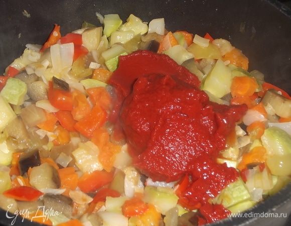 В овощи добавить томатную пасту и сахарный песок.