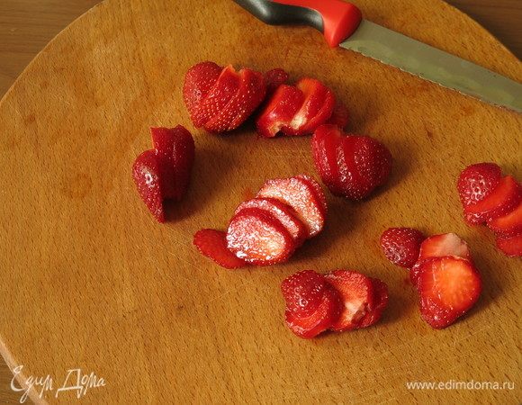 Нарезаем клубнику вдоль.