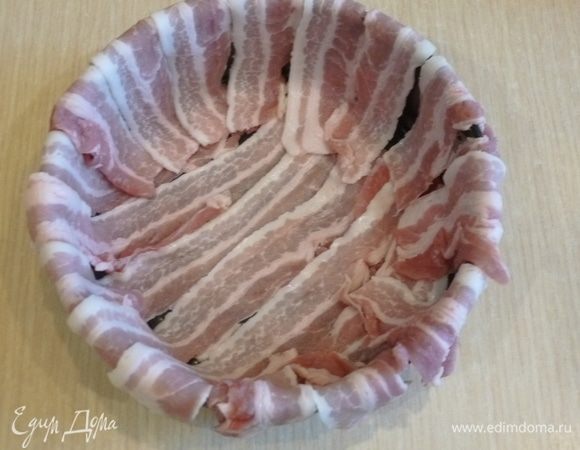 Форму для выпекания (у меня была диаметром 18 см) застелить слайсами бекона так, чтобы оставались свешиваться края.