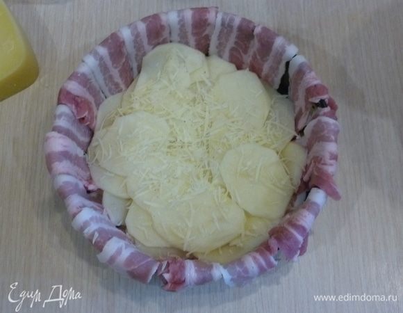 Выкладывать слои картофеля, чередуя тертым сыром. Каждый слой приправлять по вкусу солью и перцем.