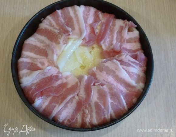 Сверху выложить слой картофеля, полить растопленным сливочным маслом и накрыть его краями бекона.