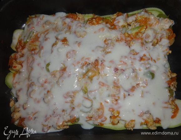 Положить на кабачки половину курино-овощной смеси. Выложить сверху 1/3 соуса.
