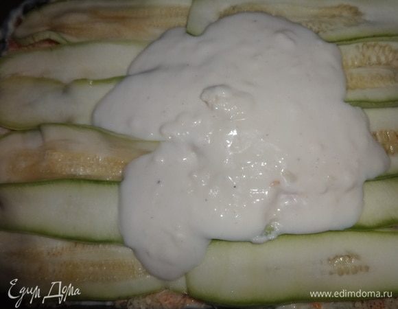 Повторить слои ещё раз в том же порядке: 1/3 кабачков, половина начинки, 1/3 часть соуса, 1/3 часть сыра. Верхним слоем выложить кабачки, на них вылить остатки соуса, распределить его по всей поверхности.