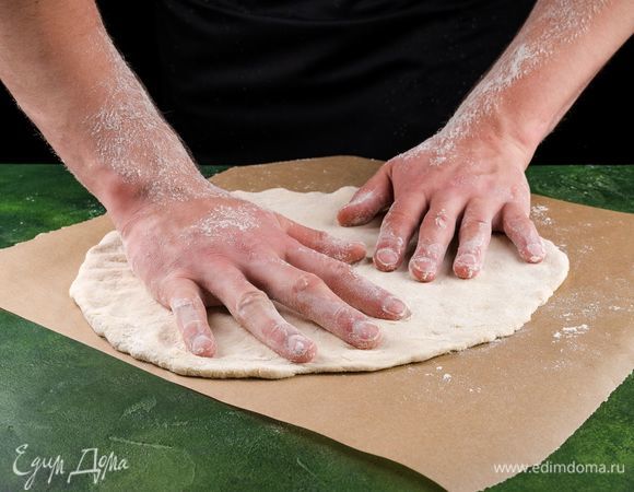 Когда тесто подойдет, раскатайте его в круглый пласт.