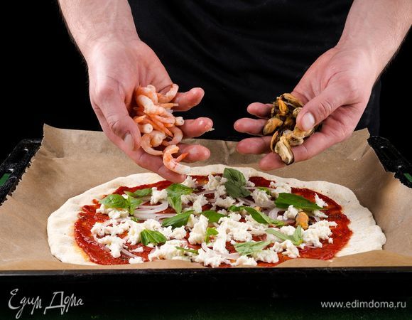 Выложите кольца репчатого лука, посыпьте измельченной моцареллой, орегано и выложите листики базилика.