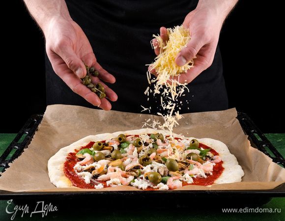 Сверху посыпьте пиццу тертым пармезаном, добавьте каперсы и оливки.