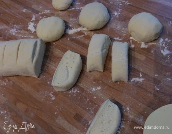 Тесто обмять. На слегка посыпанной мукой поверхности скатать тесто в удлиненный брусок. Разрезать на одинаковые шайбочки (у меня получилось 15 штук). Смазать руки растительным маслом и скатать шарики, выложить на противень, покрытый пергаментной бумагой, немного придавить ладошкой.