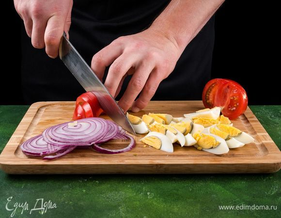 Варим яйца вкрутую. Помидор и вареные яйца нарезаем ломтиками, лук — кольцами.