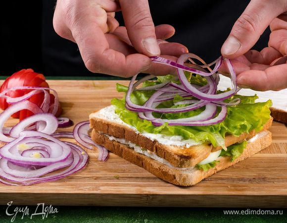 Сверху намазываем сыром, кладем салат, лук и помидор.