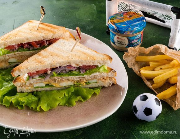 Накрываем оставшимся куском хлеба, смазанным сыром. Разрезаем каждый сэндвич на 2 части по диагонали, каждую часть закалываем шпажкой. Подаем с картофелем фри (по желанию). Футбольные фанаты будут рады такой сытной закуске!