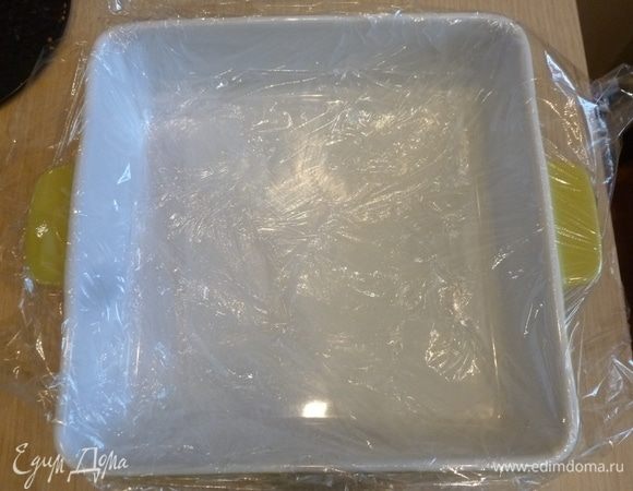 Форму застелить пленкой. Мне понадобилось два прямоугольных куска пленки, застелила крест-накрест. Застелить так, чтобы свисали края.