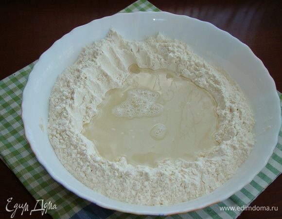 В миску просеять муку, в центре сделать лунку, влить холодную воду и всыпать соль. Замешивать тесто, начиная из центра лунки, постепенно собирая муку по краям. Как только вся мука соберется в ком, переложить тесто на стол и продолжить вымешивать руками в течение 5–10 минут. Чем дольше вымешиваем тесто, тем оно становится более эластичным.