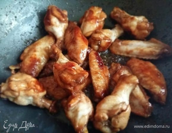 По мере того, как будет испаряться жидкость, наши крылышки начнут приобретать насыщенный, янтарный цвет. В конце добавить молотый имбирь.