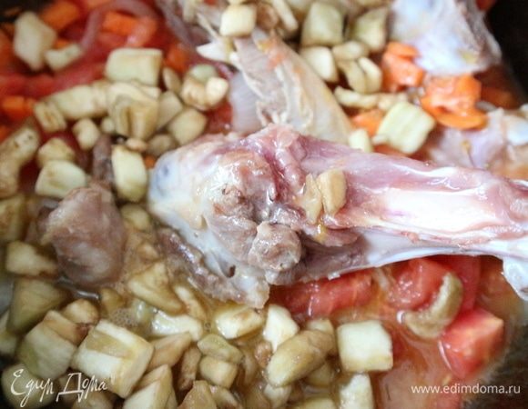 Чеснок почистить. Картофель почистить, порезать небольшими кубиками. Поместить в казан баклажаны и картофель.