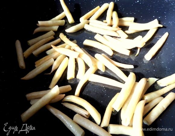 Вынуть чеснок на блюдце и в том же масле обжарить фасоль.