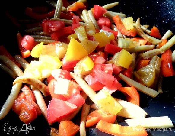 Добавить после того, как овощи минут 5 обжарятся. Томатам достаточно пробыть в сковороде минуту.