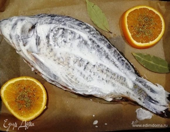 Смазываем нашего сазана сметаной и отправляем в духовку, разогретую до 200⁰С, на 20 минут.