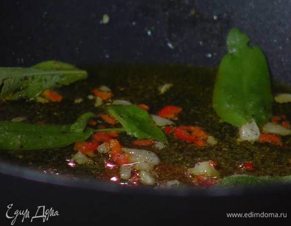 Перец чили, удалив семена, мелко порубить и отправить к чесноку, затем снять сковороду с огня, добавить листья шалфея, все посолить и поперчить.
