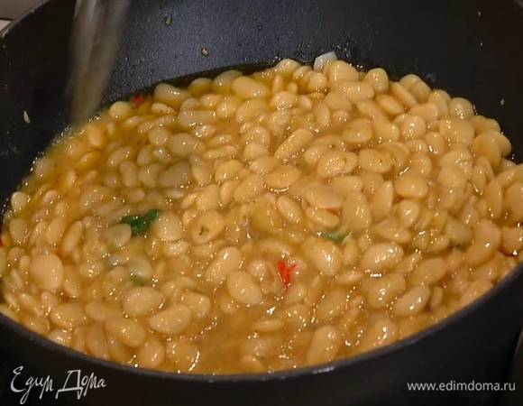 Фасоль отварить без добавления соли согласно инструкции на упаковке, затем выложить в сковороду с чесноком и чили, поместить на огонь и, помешивая, немного прогреть.
