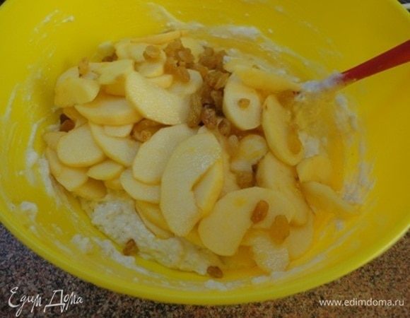 Сюда же подмешиваем яблоки с изюмом, предварительно отложив несколько для украшения. Перемешиваем и выкладываем в форму для запекания.