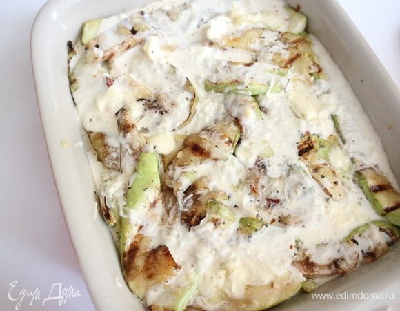 Залить лук и картофель частью яично-сливочной смеси. Поместить сверху кабачки, залить оставшейся смесью. Сверху поместить небольшие кусочки подтаявшего сливочного масла.