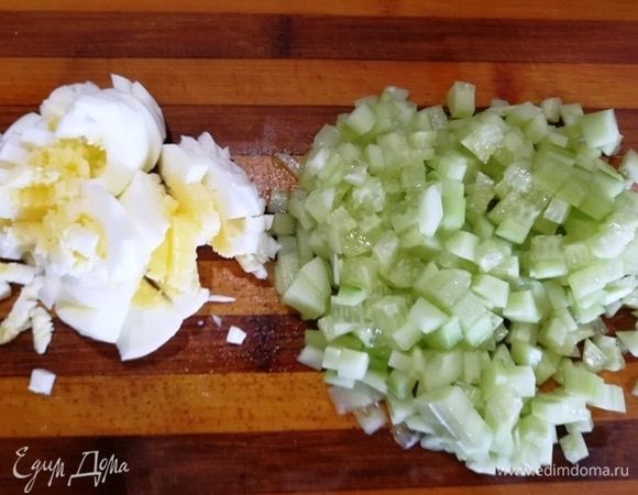 Нарезаем вареные яйца и очищенный от шкурки огурец.