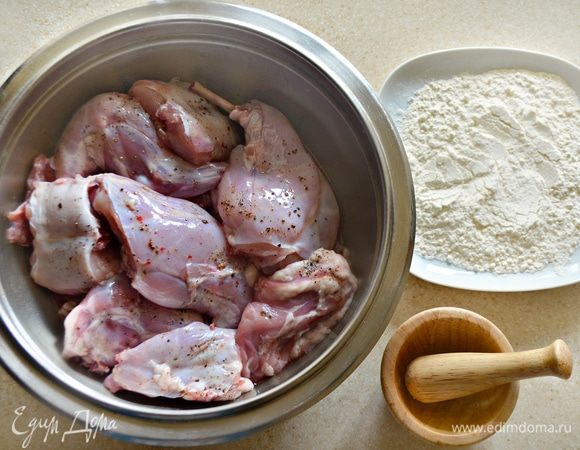После этого тушку обсушить с помощью бумажных полотенец и нарезать на порционные куски. Посолить, поперчить и обвалять каждый кусочек кролика в муке.