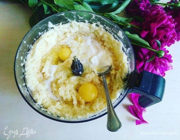 Измельчаем в кухонном комбайне, у меня мелкая терка. Сперва нужно измельчить луковицу, затем картофель. Добавим 2 яйца. И для того, чтобы картофельная масса меньше темнела, добавляем сметану. Перемешиваем, добавляя муку. Солим по вкусу. Картофельная масса для идеальных драников готова.