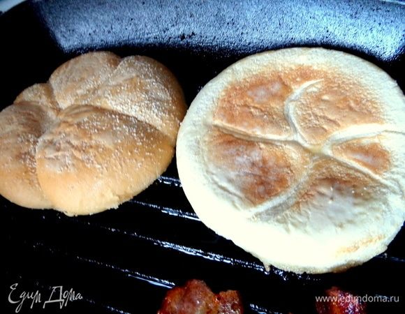 Рядом с беконом обжарить половинки булочки для гамбургеров.